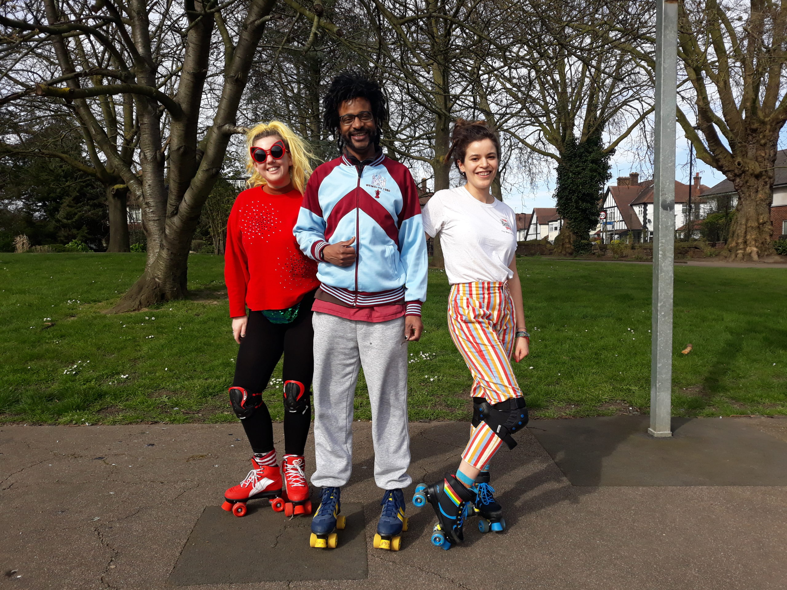 Three friends rollerskating in the park