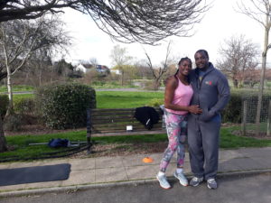 A couple pose during a workout in the park